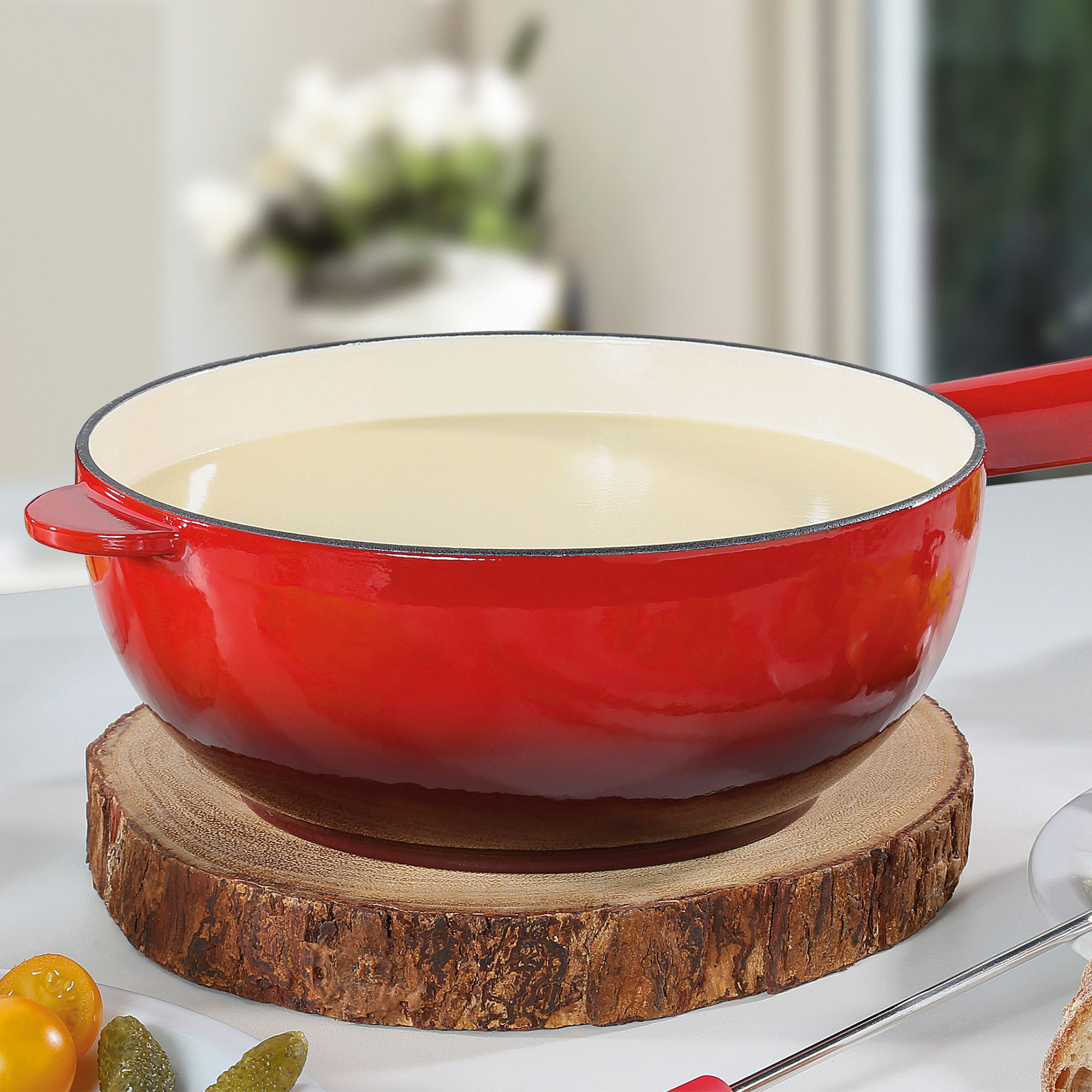 Red cast iron fondue pot with light interior