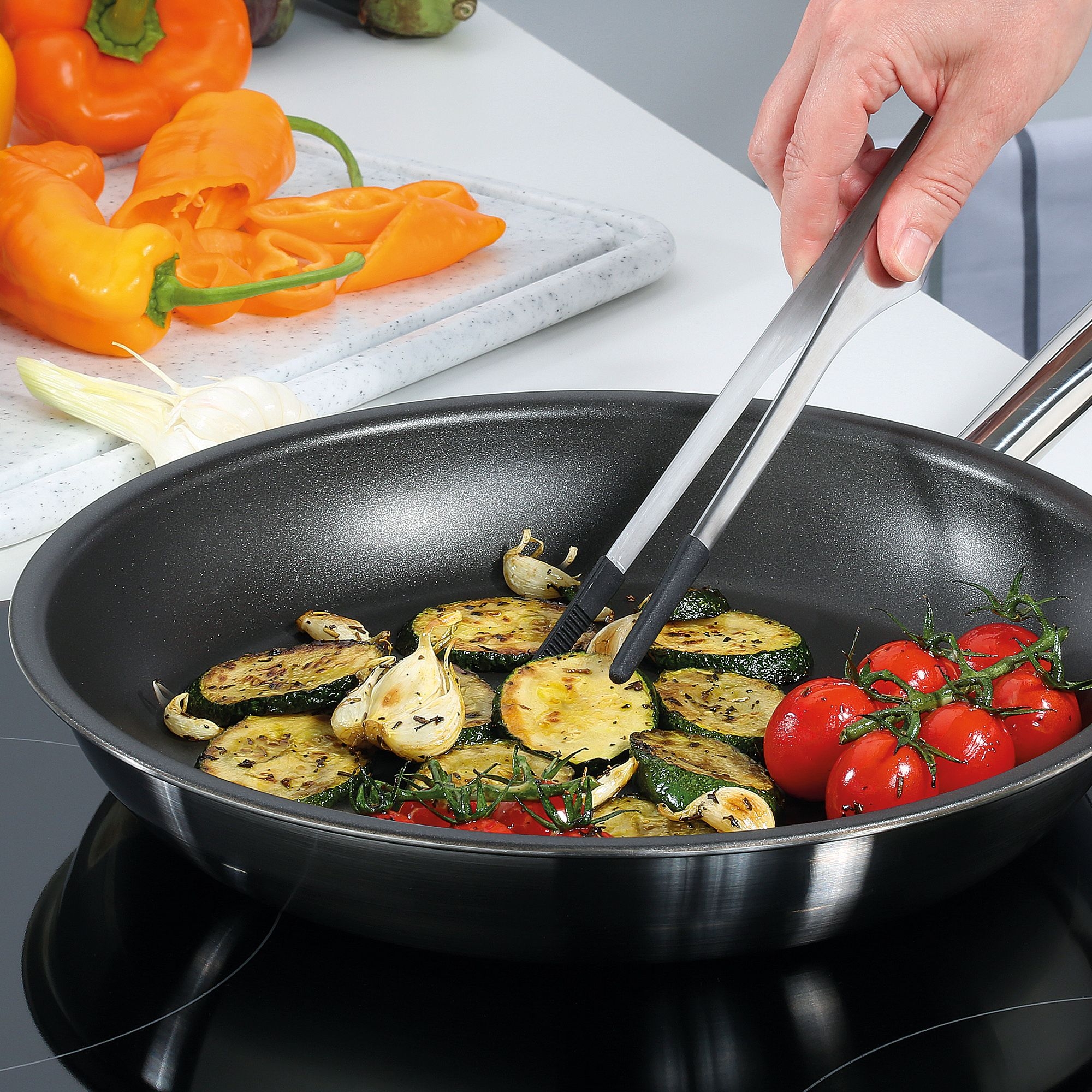 Pfanne mit gebratenem Gemüse wie Zucchini, Tomaten und Knobl